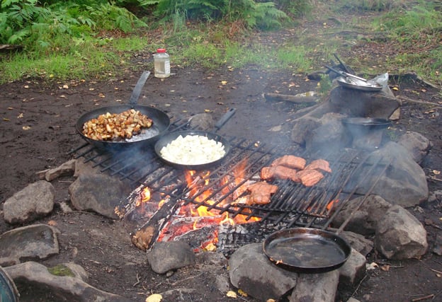 Fresh salmon cooking on the open fire on the river banks