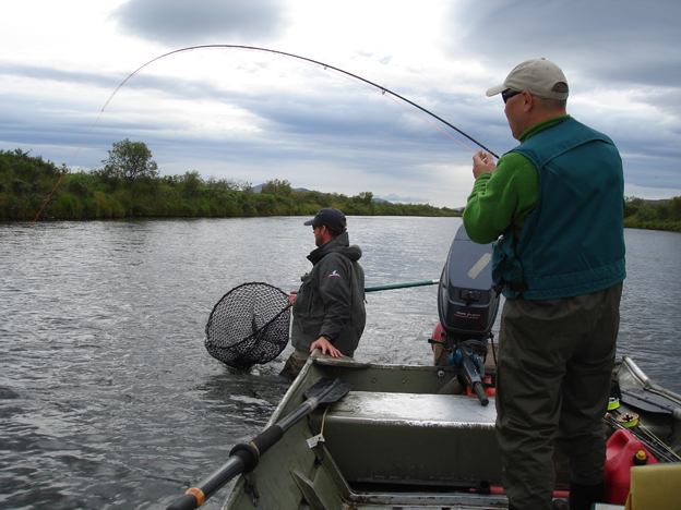 Customer playing a Salmon in Alaska from the guides boat