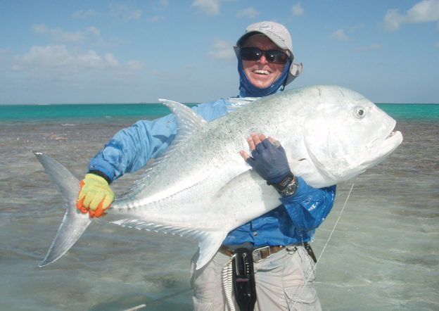 Angler crouches with his trophy fish