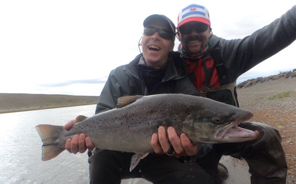 customers looking very happy holding a sea trout argentina