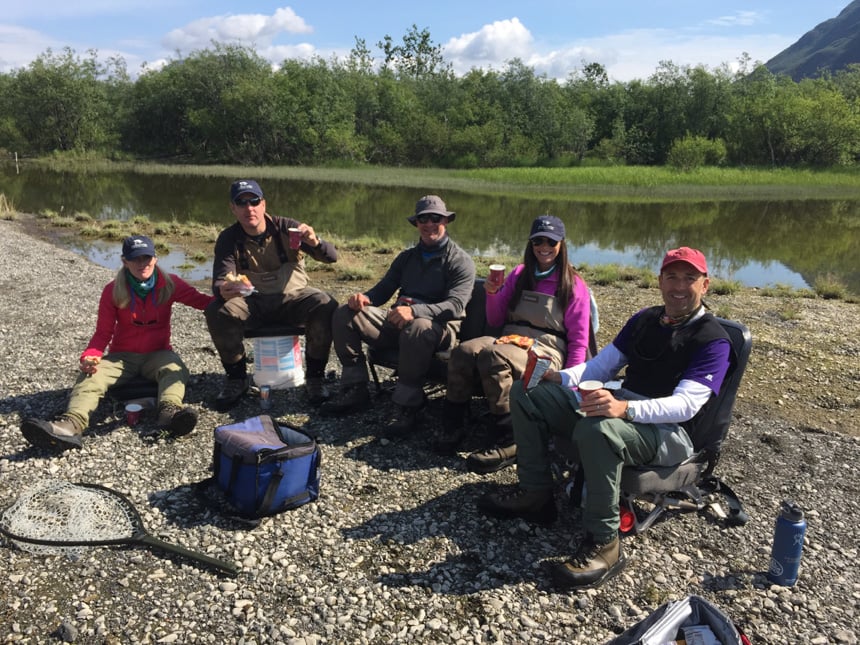 customers enjoying a shore lunch while fly fishing for salmon in alaska