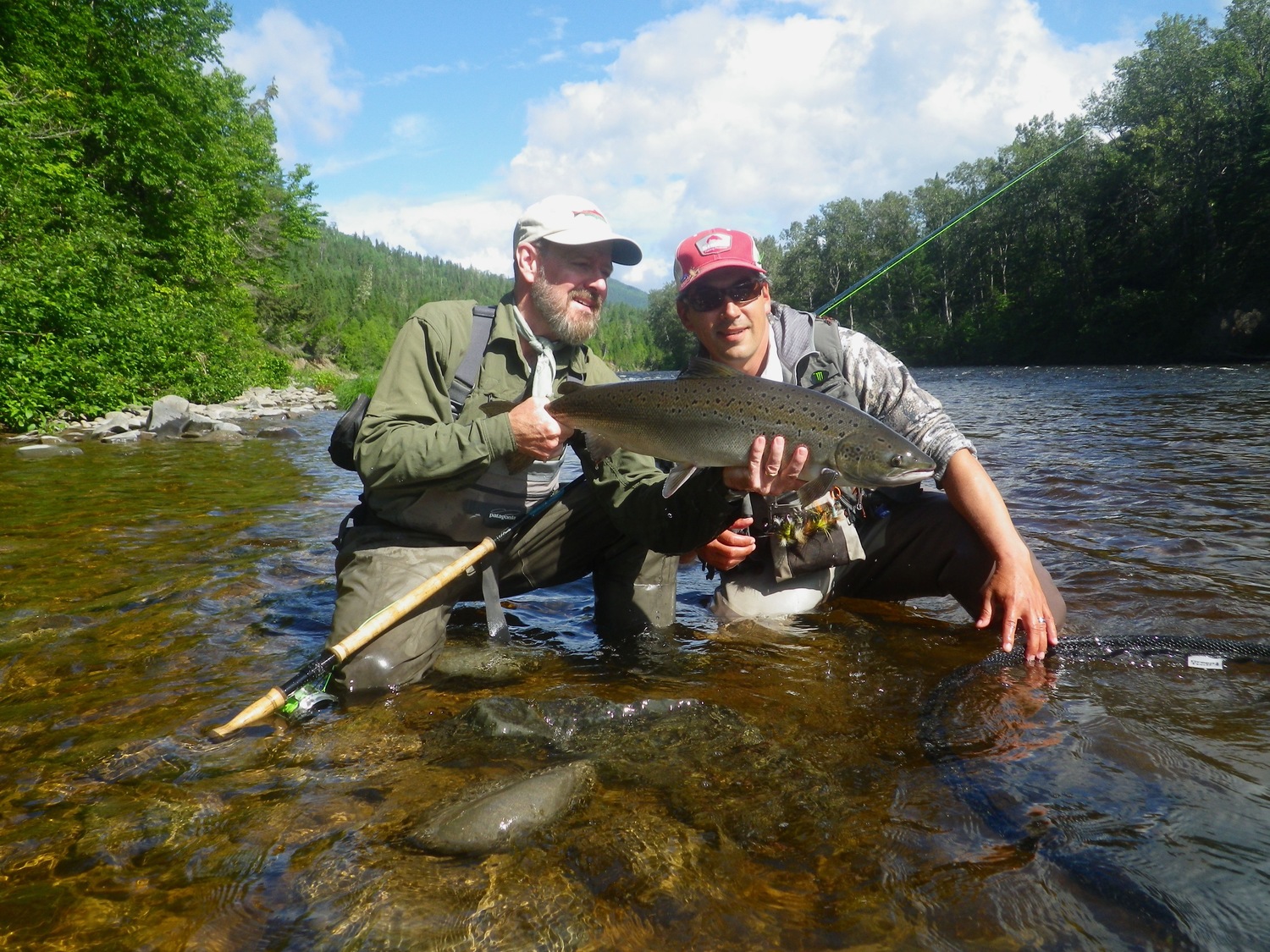 Happy Customer holding up an Atlantic Salmon caught on the fly Canada