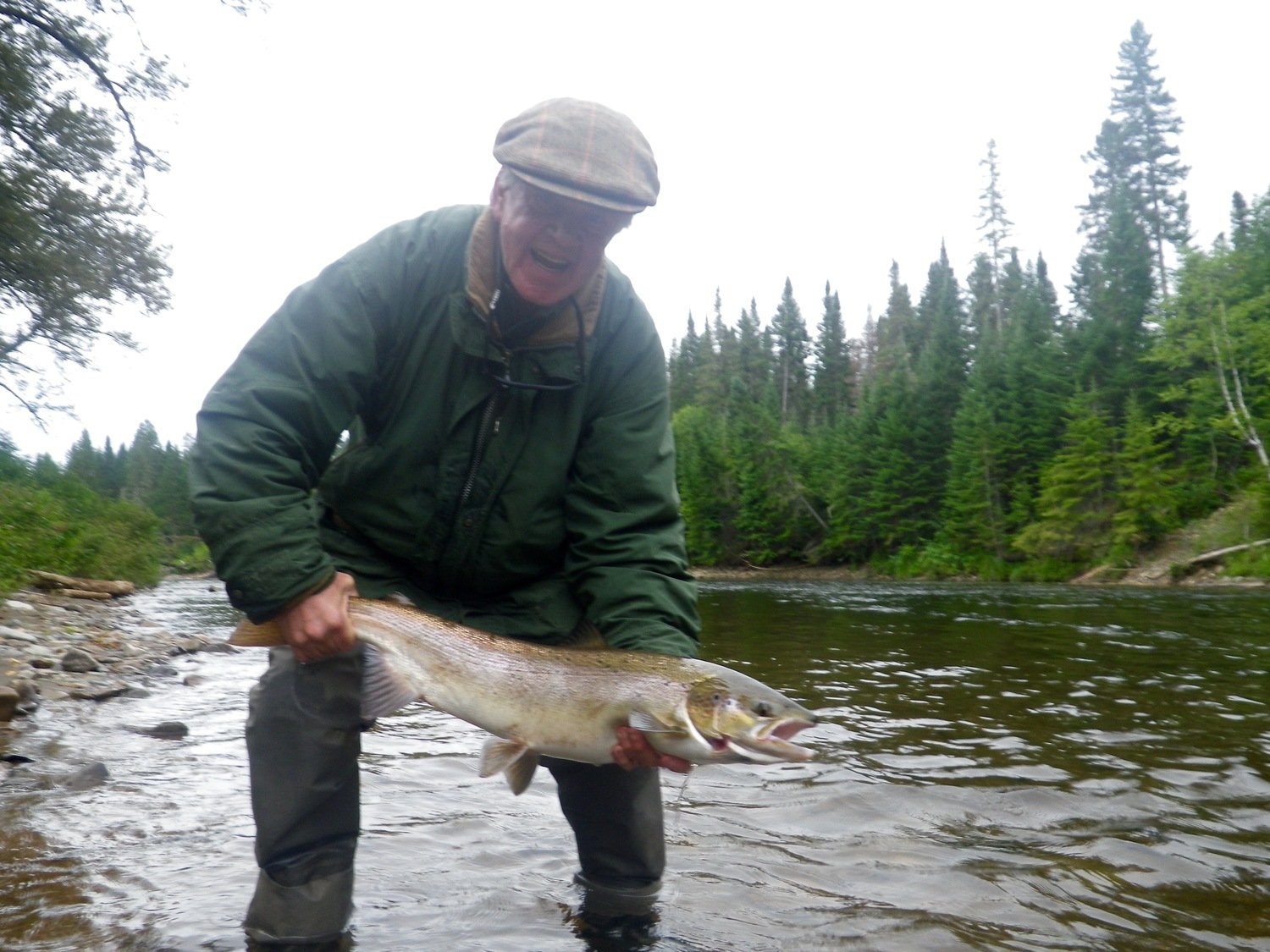 Salmon Lodge Fishing Report with a Happy customer holding the Atlantic Salmon from above as this one did not get away.