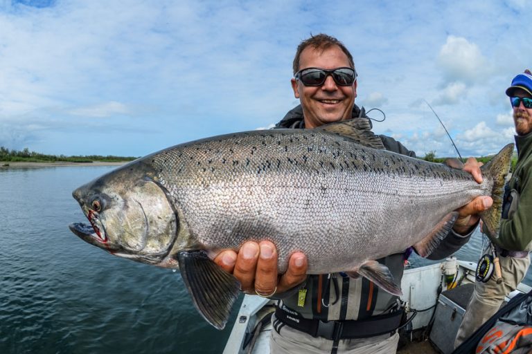 customer holding up a very short fat silver salmon from thje goodnews.