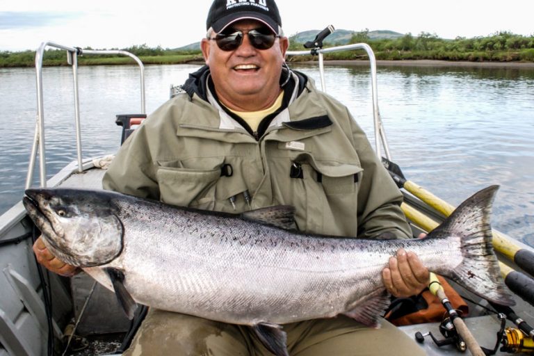 customer in boat holding a nice 30lb chinook salmon from the goodnews river