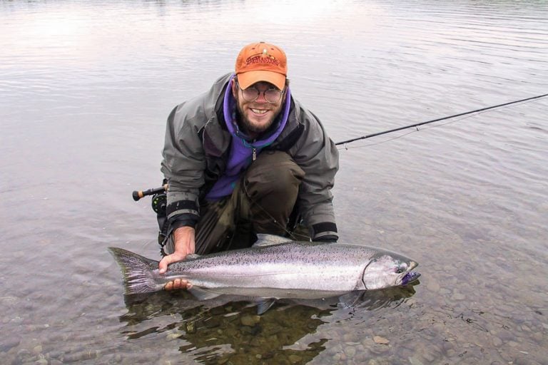 customer holding in the water a nice fat chinook in the Goodnews River Alaska