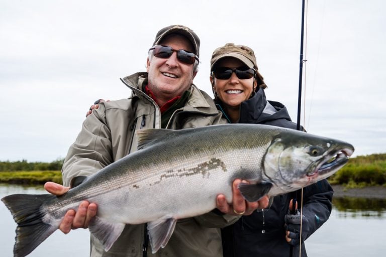 Two very happy people holding up a fresh silver salmon
