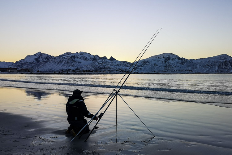 Angler setting up his rod on the beach 