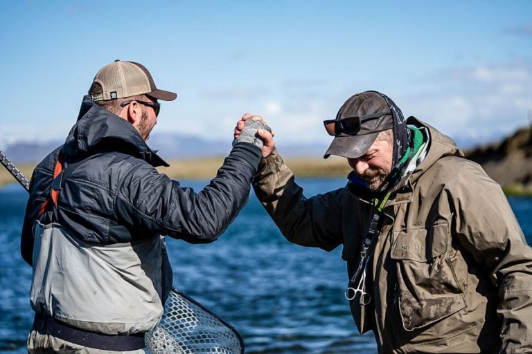 customer and guiding shaking hands looking very happy as they have just caught an atlantic salmon