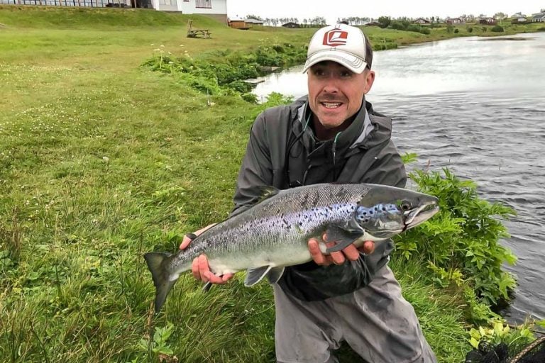 Customer in a white hat holding a fresh Atlantic Salmon from Iceland