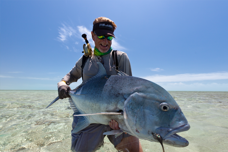 Small Fish Hanging on a Fishing Line on the Background of Blue